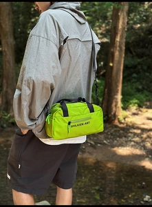 Detail of neon green nylon gym bag featuring water-resistant fabric and zipper pocket