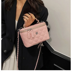 Détail du sac à main rose matelassé avec fleur en argent et bandoulière en chaîne