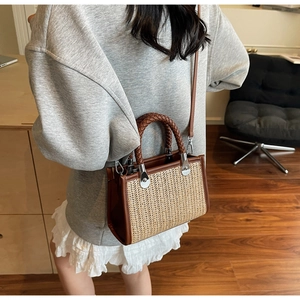 Close-up of woven straw texture and brown leather details on a stylish crossbody handbag
