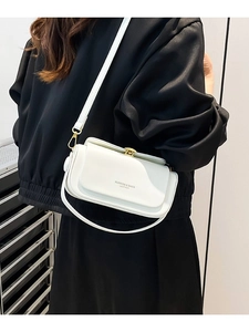 Elegant white leather crossbody bag with gold buckle shown on shoulder for a stylish look