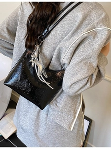Sac seau chic en similicuir brillant noir avec breloques argentées pour look décontracté