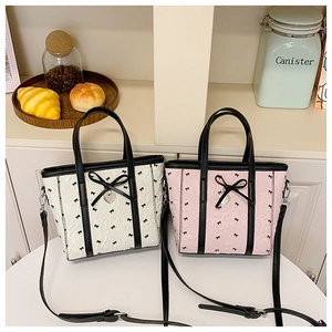 Détail du sac seau en nylon avec nœuds, pendentif cœur et finitions en similicuir