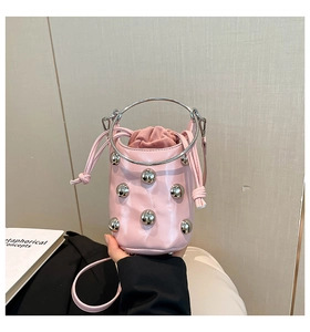 Rosafarbene Beuteltasche mit Nieten, Metallgriff und innerem Kordelzug im Detail