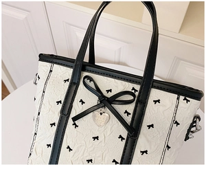Vue détaillée du sac seau en nylon avec nœuds noirs et pendentif en forme de cœur argenté