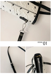 Détails d'un sac cabas blanc avec motif chiot noir et boucle de crochet en métal argenté
