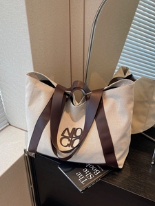 Large capacity canvas tote bag with brown leather handles for commuting or travel