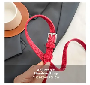 Détail de la bandoulière en cuir grainé rouge avec boucle en métal argenté réglable