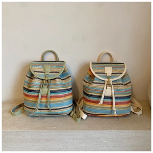 Détail de sacs à dos en paille tressée colorée avec lanières en cuir et cordon