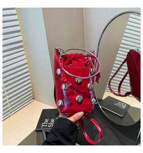 Detailansicht der roten Beuteltasche mit silbernen Rundnieten und Metallgriff