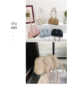 Detailed view of large bowling bags in various colors with textured leather and metal studs