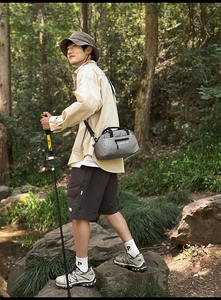 Outdoor nylon crossbody bag in gray with adjustable strap and front zipper detail