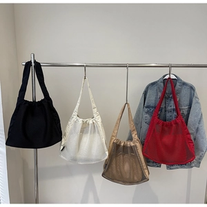 Detail of multi-color hollow nylon mesh tote bags with drawstring closure for summer