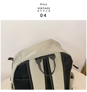 Detail of gray grid pattern nylon backpack with breathable black mesh back and sturdy handle