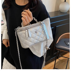 Vanity bag argenté matelassé avec bandoulière chaîne et détail fleur sur modèle