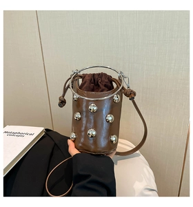 Detail der braunen Leder-Eimertasche mit Silbernieten und rundem Metallgriff