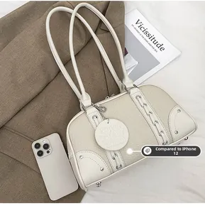 Detail view of cream Boston bag with woven rope design, silver studs and leather tag