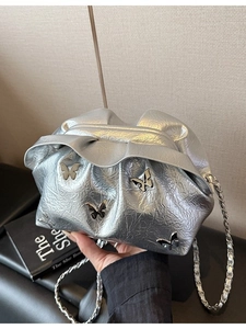 Silver metallic cloud bucket bag with pleats, butterfly charms, and chain strap