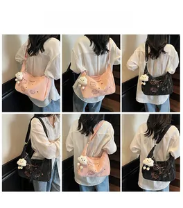Close-up of pink nylon tote bag featuring cute cat print and fluffy cloud pendant charm