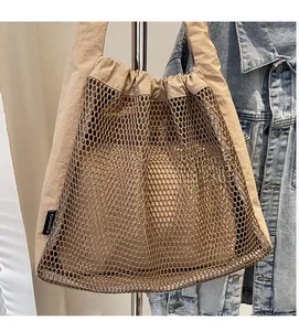 Close-up of beige mesh tote bag featuring a brand woven label and durable nylon fabric