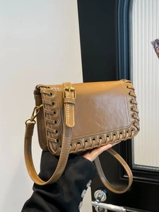 Caramel brown leather crossbody bag with woven edges and vintage gold metal buckles