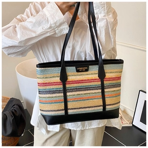 Detail of the colorful striped woven straw tote bag with black leather handle and logo