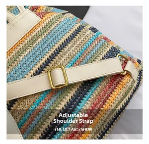 Détail de la bandoulière réglable et des boucles dorées sur un sac à dos tissé à rayures