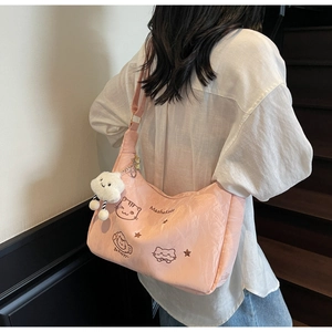 Detail of pink tote with cartoon cat embroidery and a plush cloud charm on the shoulder strap