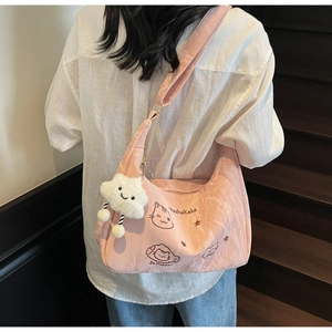 Detail of pink half-moon crossbody bag with cat embroidery and cloud plush charm