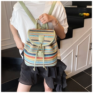 Détail d'un sac à dos tissé coloré avec des lanières en cuir vert et des ferrures dorées