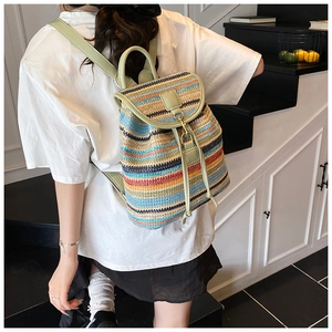 Sac à dos tressé coloré avec des bretelles en cuir vert clair porté par un mannequin