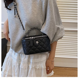 Sac seau matelassé noir chic avec bandoulière chaîne argentée et breloque fleur