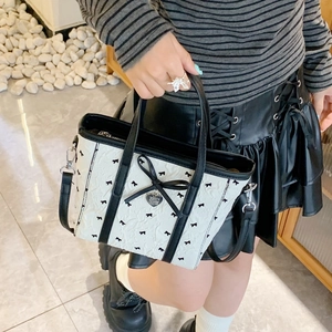 Gros plan d'un sac seau en nylon noir et blanc avec texture 3D et nœud en soie