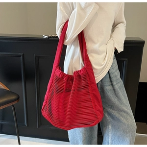 Detail of red hollow mesh tote bag showing large capacity and breathable woven fabric