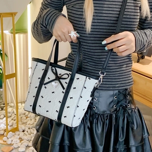 Sac fourre-tout blanc à motifs nœuds noirs avec pendentif cœur en situation réelle