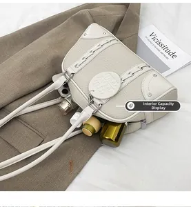 Close-up of beige pebbled leather underarm bag with silver rivets and interior storage