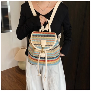 Détail d'un sac à dos tissé à rayures multicolores avec sangles en cuir beige et cordon