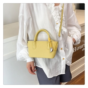 Détail du sac seau jaune clair en cuir PU grainé avec pendentif en métal argenté