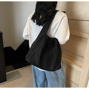 Close-up of lightweight black mesh tote bag showing breathable texture and wide strap