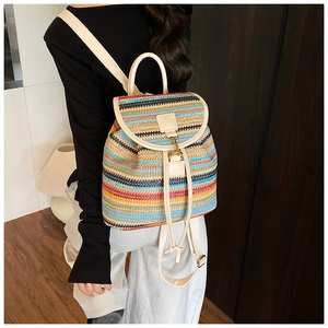 Détail du sac à dos tissé à rayures colorées montrant les bretelles en cuir et le fermoir