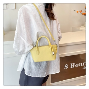 Sac seau jaune chic avec motif litchi porté par un mannequin dans un décor minimaliste
