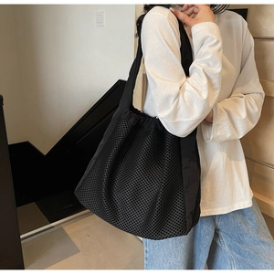 Detail view of black nylon mesh tote bag with drawstring closure for casual wear