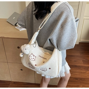 Detail of white tote bag with cute cat illustration and soft cloud plush pendant