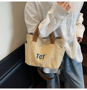 Détail du sac cabas en toile avec poche avant, broderie TCT et poches latérales