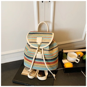 Détail d'un sac à dos tissé à rayures colorées avec rabat en cuir crème et boucle dorée