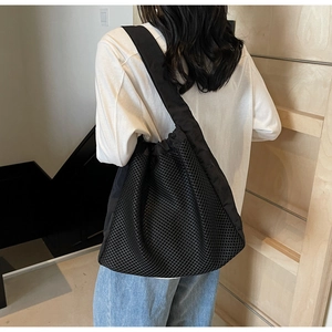 Detail of black honeycomb mesh tote bag with wide ergonomic shoulder straps for travel
