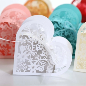 Close-up of laser-cut hollow heart gift box with floral patterns and satin ribbon bow