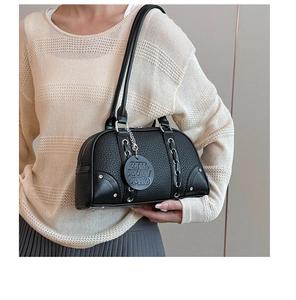 Detail of black lychee grain leather pillow bag with silver metal ring and strap