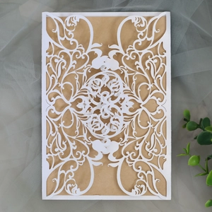 Detail of laser-cut floral pattern invitation sleeve with vintage kraft paper insert
