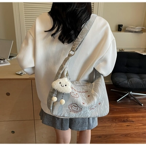 Detailed embroidery of cat and star patterns on silver-grey wrinkled fabric tote bag