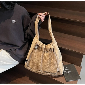 Detailed macro view of the beige mesh stitching and drawstring design on the tote bag
